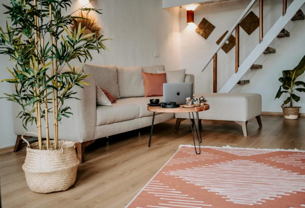 A stylish living room featuring a cozy sofa, wooden coffee table, and vibrant indoor plants, creating a warm atmosphere.